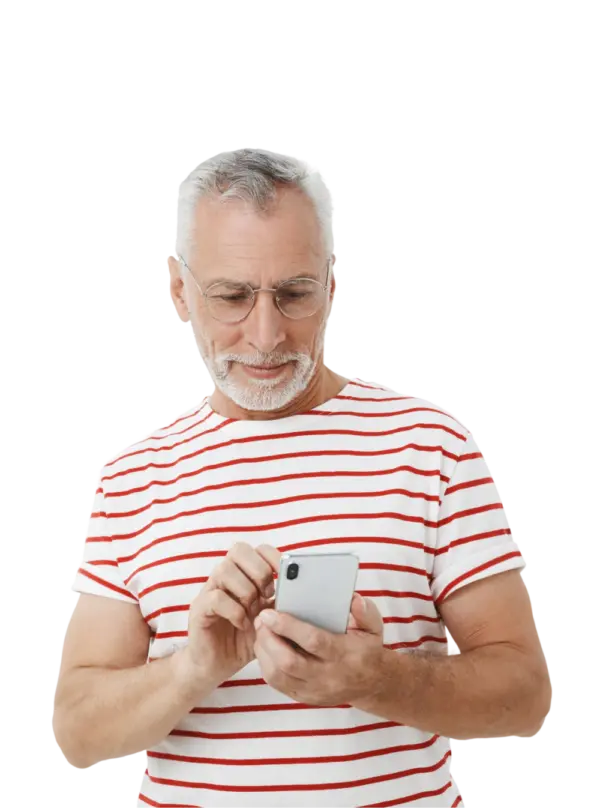 Starszy mężczyzna w siwych włosach i okularach, patrzy na telefon w ręku i przegląda aplikację Galerii Solnej. Ubrany w tshirt w czerwone paski.